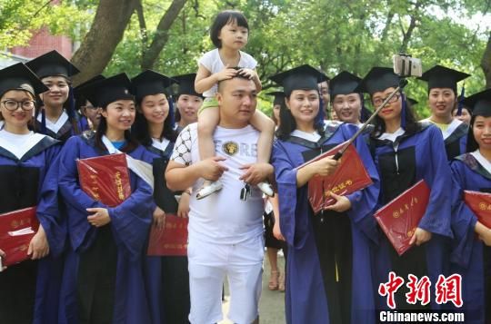 　南华大学硕士毕业生携子参加毕业典礼。　曹正平 摄