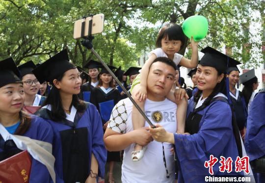 　南华大学硕士毕业生携子参加毕业典礼。　曹正平 摄
