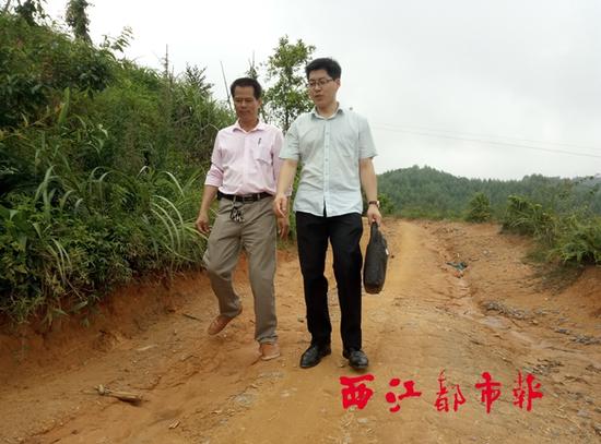 看着眼前的山路,马天宝(右)与村委主任高宝年商量,近期将邻村的村支书约在一起,共同商讨这条道路的修整工作。
