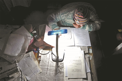 邹伟敏在家中挑灯夜读。