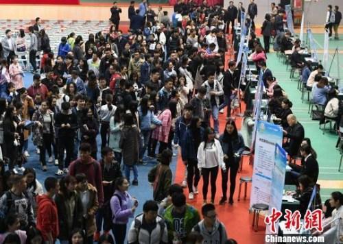 资料图：众多大学生扎堆招聘现场求职。杨华峰 摄